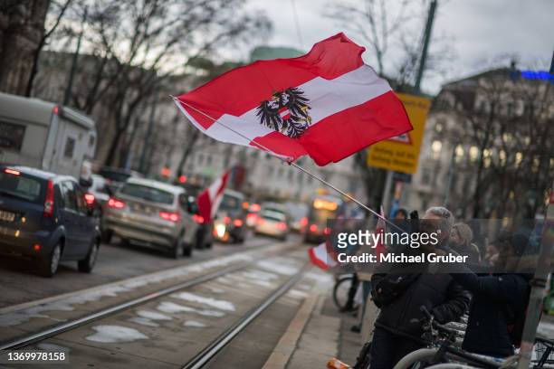 Anti-coronavirus lockdown measures and anti-vaccination protesters hold an Austrian flag in a gathering inspired by the current "Freedom Convoy"...