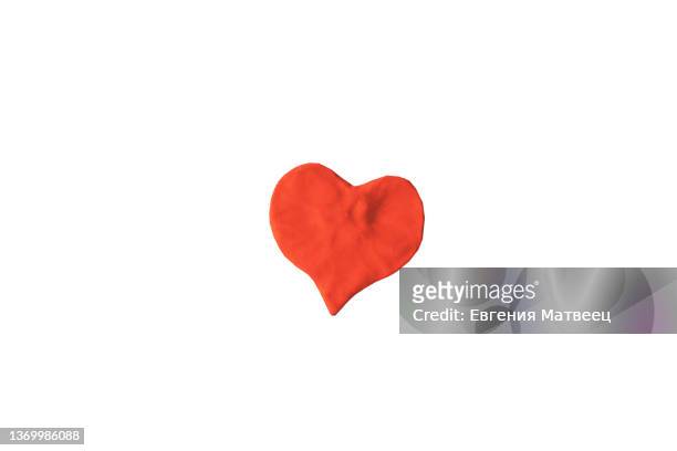 red heart shape molded from plasticine modeling clay isolated on white background close-up - clay foto e immagini stock