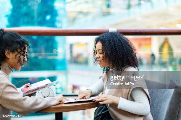 two african women in shopping mall - restaurant women friends lunch stock pictures, royalty-free photos & images