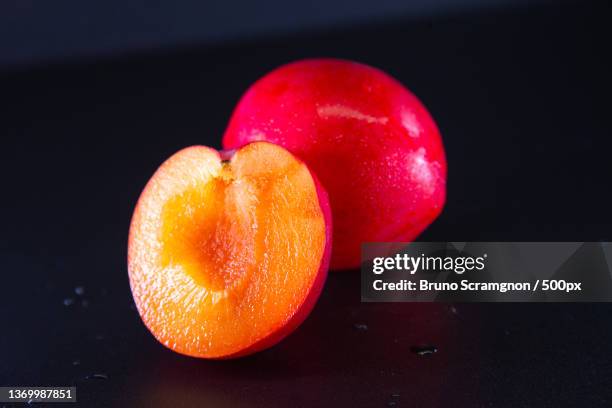 fresh red plum in black background,close-up of fruits on table,rio de janeiro,brazil - orgânico stockfoto's en -beelden