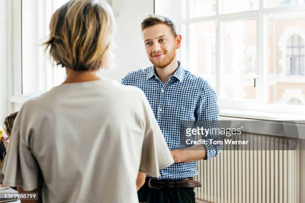 pupil talking to tutor after seminar session - school teacher blue stock-fotos und bilder