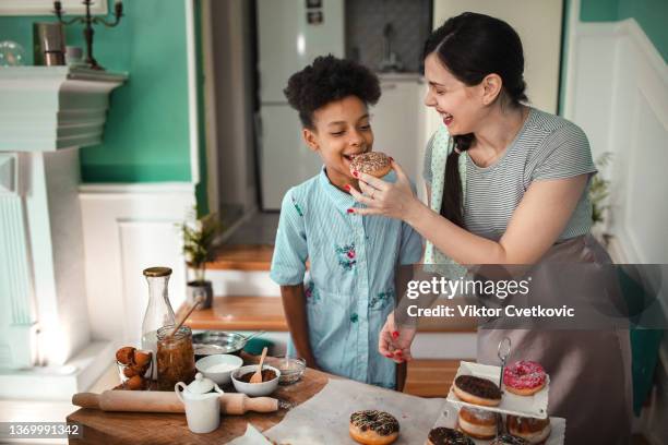 happy multinational family in kitchen making doughnuts - friends donut stock pictures, royalty-free photos & images