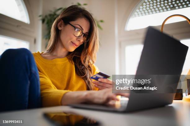 hermosa joven que trabaja en casa - charging fotografías e imágenes de stock