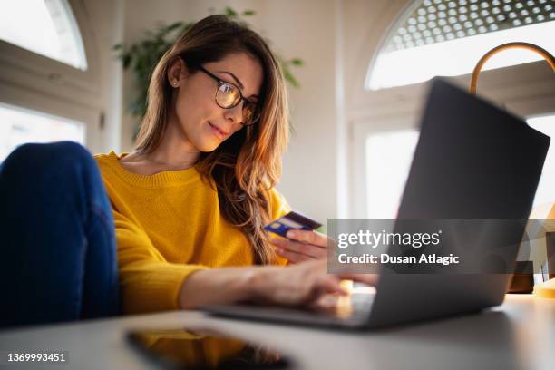 beautiful young woman working at home - credit card stock pictures, royalty-free photos & images
