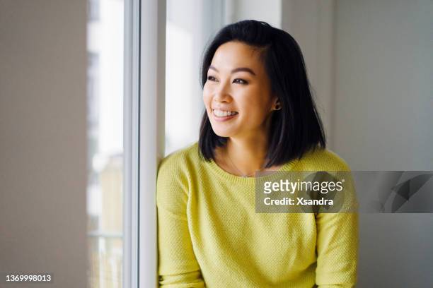 smiling woman standing by the window at home - orthodontics stockfoto's en -beelden