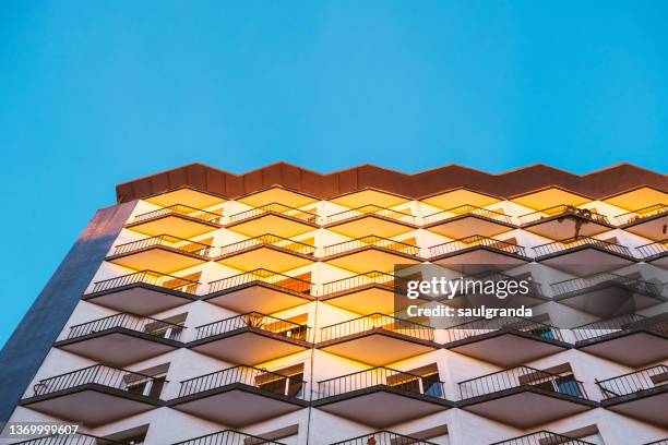 apartment building facade illuminated by the sun - building story stock-fotos und bilder