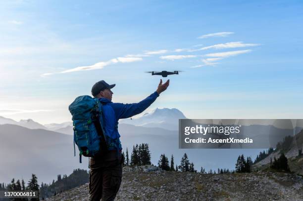 man launching a drone on a hike - drone pilot stock pictures, royalty-free photos & images