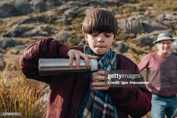 boy pouring water in the natural park - flask stock pictures, royalty-free photos & images