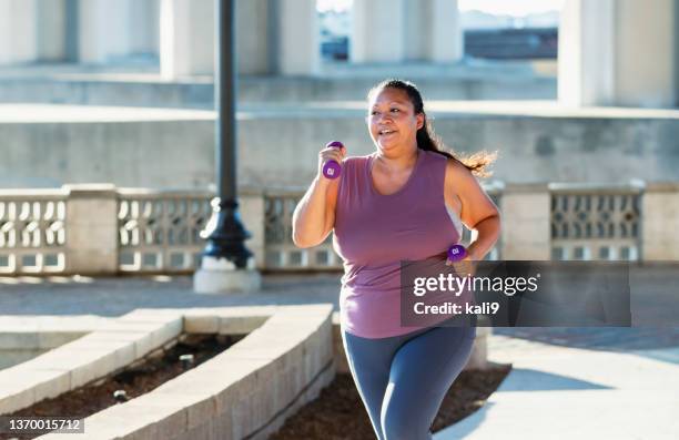 pacific islander frau läuft unter der stadtbrücke - power walking stock-fotos und bilder