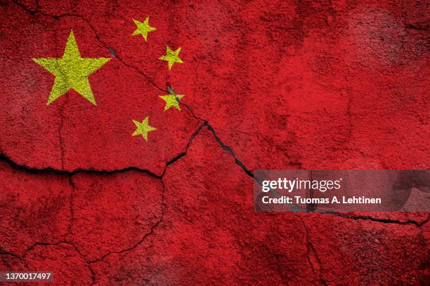 full frame photo of a weathered flag of china painted on a cracked wall. - chinese vlag stockfoto's en -beelden