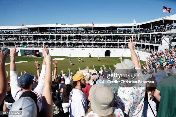 Garrick Higgo of South Africa throws his ball to the fans after a putt on the 16th hole during the second round of the WM Phoenix Open at TPC...