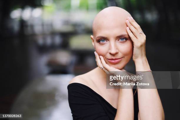 a close-up portrait of a young girl suffering from breast cancer or alopecia. victory over the disease cancer - 完全に禿げている頭 ストックフォトと画像