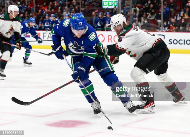 Jakob Chychrun of the Arizona Coyotes checks Bo Horvat of the Vancouver Canucks during their NHL game at Rogers Arena February 8, 2022 in Vancouver,...