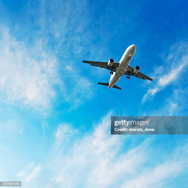 xl jet airplane landing in bright sky - cargo aeroplane stock pictures, royalty-free photos & images