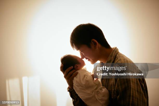 silhouettes of generation z fathers and newborns in profile. - baby father hug side stock pictures, royalty-free photos & images