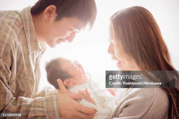 portrait of generation z couple and their newborn baby - familia de dos generaciones fotografías e imágenes de stock
