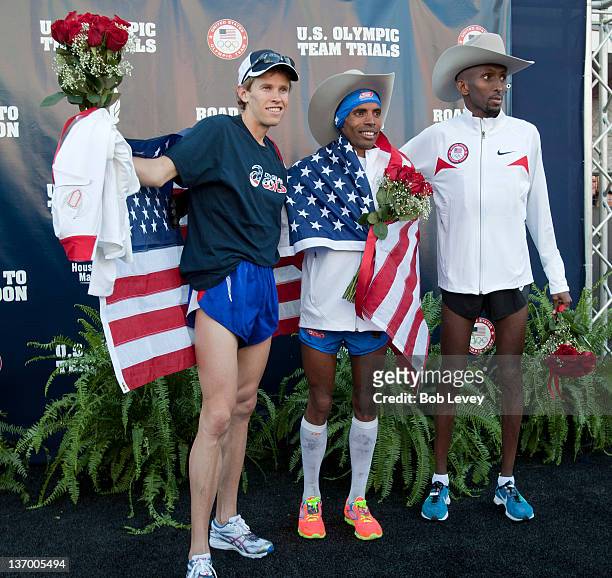 Ryan Hall, Meb Keflezighi and Abdi Abdirahman pose with their cowboy hats on the stage after qualifying for the U.S. Marathon Olympic Trials on...