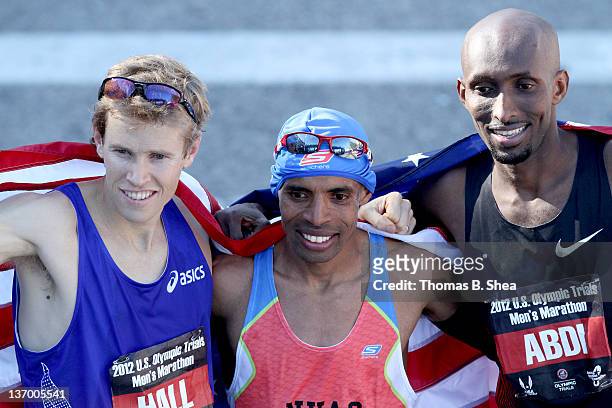 Ryan Hall, Meb Keflezighi and Abdi Abdirahman celebrate holding the American flag after they competed in the U.S. Marathon Olympic Trials January 14,...