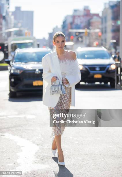 Leonie Hanne seen wearing sheer skirt, white blazer, silver Balenciaga bag, white top outside Bronx & Branco during New York Fashion Week on February...