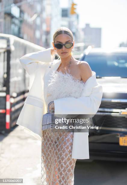 Leonie Hanne seen wearing sheer skirt, white blazer, silver Balenciaga bag, white top outside Bronx & Branco during New York Fashion Week on February...