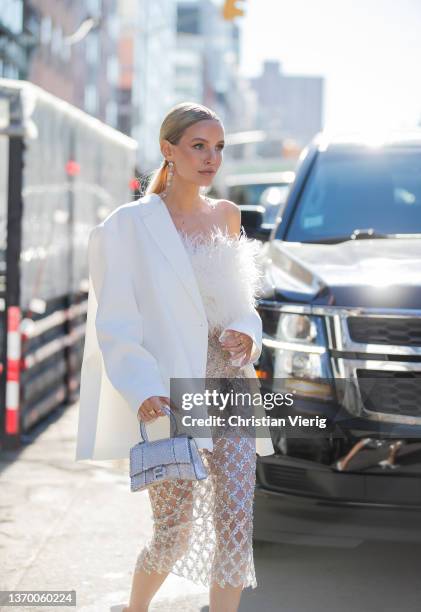 Leonie Hanne seen wearing sheer skirt, white blazer, silver Balenciaga bag, white top outside Bronx & Branco during New York Fashion Week on February...