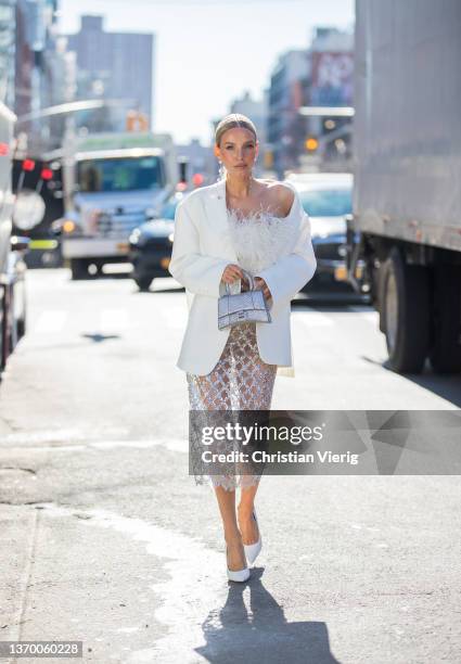 Leonie Hanne seen wearing sheer skirt, white blazer, silver Balenciaga bag, white top outside Bronx & Branco during New York Fashion Week on February...