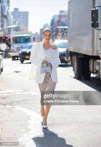 Leonie Hanne seen wearing sheer skirt, white blazer, silver Balenciaga bag, white top outside Bronx & Branco during New York Fashion Week on February...