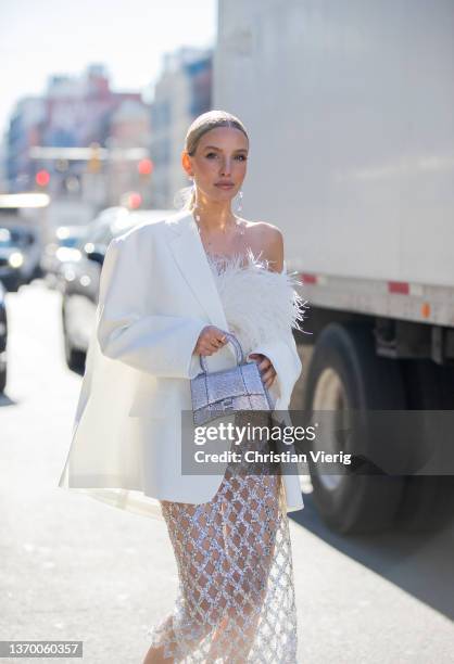 Leonie Hanne seen wearing sheer skirt, white blazer, silver Balenciaga bag, white top outside Bronx & Branco during New York Fashion Week on February...