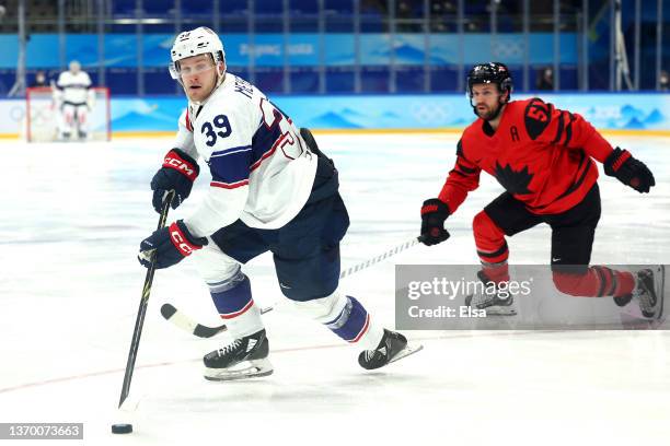 Ben Meyers of Team United States stick handles the puck away from David Desharnais of Team Canada in the third period during the Men's Ice Hockey...