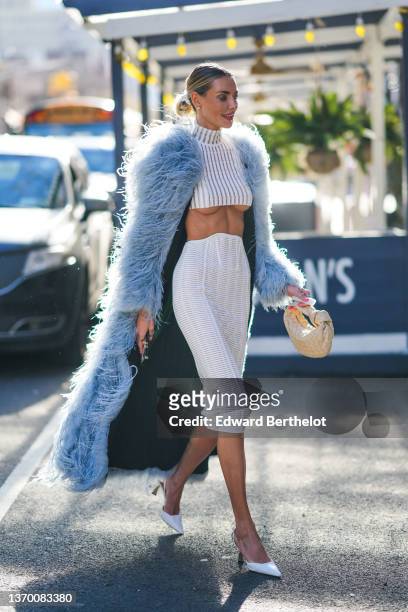 Guest wears diamond earrings, a white and tulle striped pattern turtleneck cropped long sleeves t-shirt, a white leather striped high corset tube...