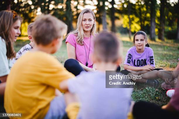 i bambini delle scuole imparano l'ecologia, la natura e l'ambiente con l'insegnante - bambini seduti in cerchio foto e immagini stock