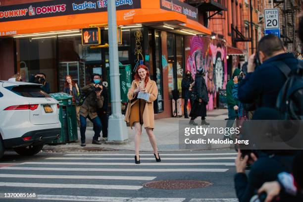 Model and Musician Karen Elson takes a photo of the crowd on her iPhone and weasr a tan coat outside the Proenza Schouler FW22 show during New York...