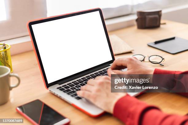 man working on a laptop computer with a blank white screen. - parte del cuerpo humano fotografías e imágenes de stock