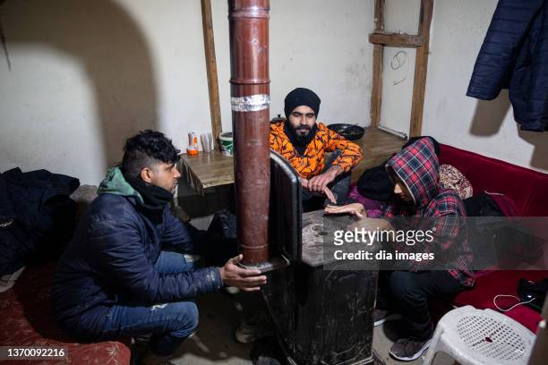 Refugees who want to cross into Europe illegally through Turkey protect themselves from the cold in their shelter on February 11, 2022 in Edirne,...