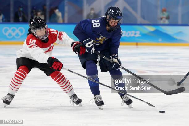 Jenniina Nyland of Team Finland challenges Haruka Toko of Team Japan in the first period during the Women's Ice Hockey Quarterfinal match between...