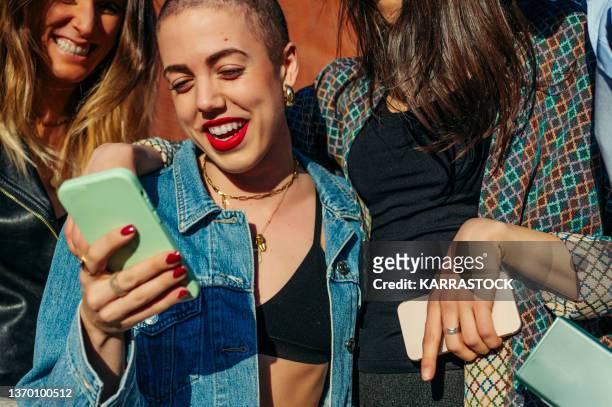 group of friends in the street with smartphone - young adult imagens e fotografias de stock