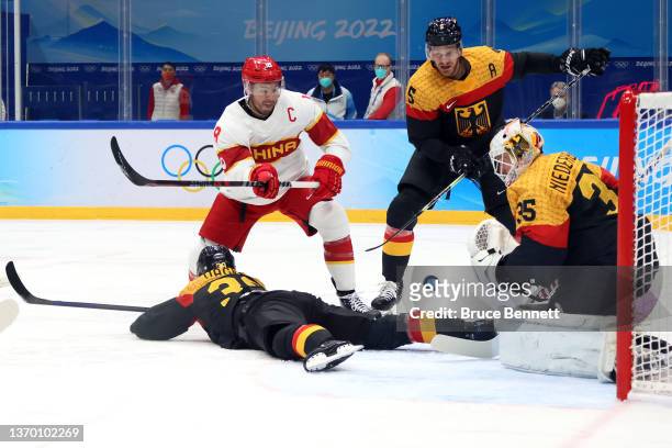 Mathias Niederberger, goaltender of Team Germany makes a save against Jinguang Ye of Team China in the second period during the Men's Ice Hockey...