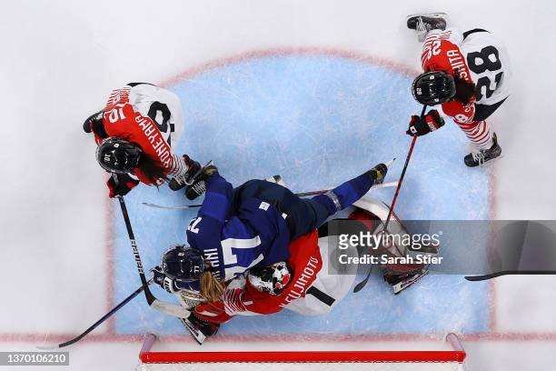 Susanna Tapani of Team Finland crashes into Nana Fujimoto, goaltender of Team Japan in the frist period during the Women's Ice Hockey Quarterfinal...
