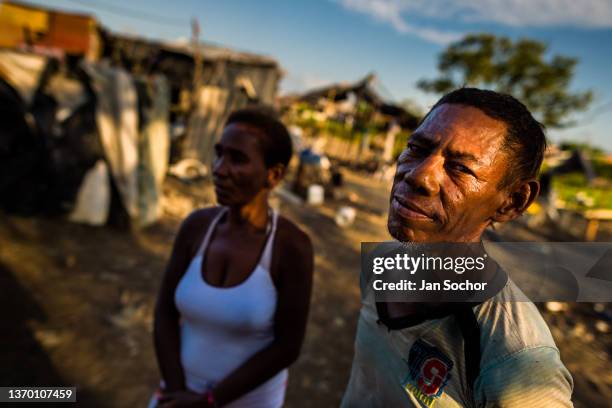 An Afro-Colombian fisherman and his wife looks on in front of their house on December 12, 2018 in Olaya Herrera, a low social class neighborhood in...