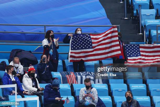 Shaun White and physiotherapist Dr. Esther Lee of Team United States look on with team members from the stands during the Ice Dance Rhythm Dance on...