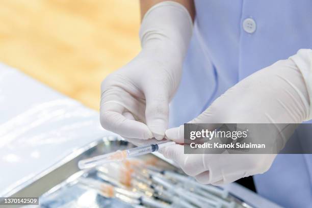 gloved hand holding a syringe - dose bildbanksfoton och bilder