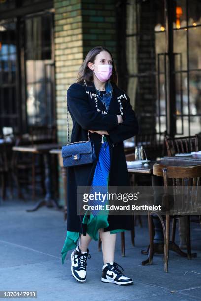 Guest wears a gold chain pendant necklace, a black t-shirt, a blue denim jacket, a royal blue electric pleated and green satin asymmetric midi skirt,...
