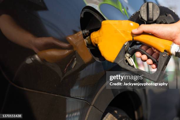 man filling up car with petrol, close-up - oil prices stock pictures, royalty-free photos & images