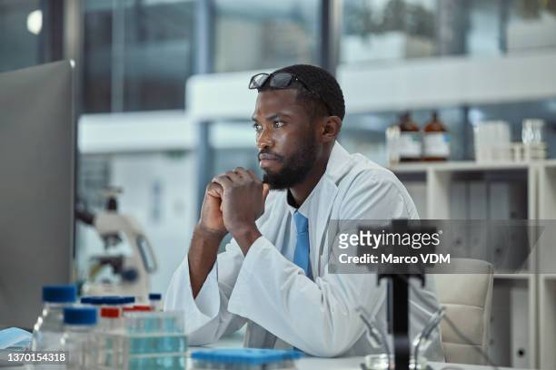 shot of a young scientist working on a computer in a lab - physicist stock pictures, royalty-free photos & images