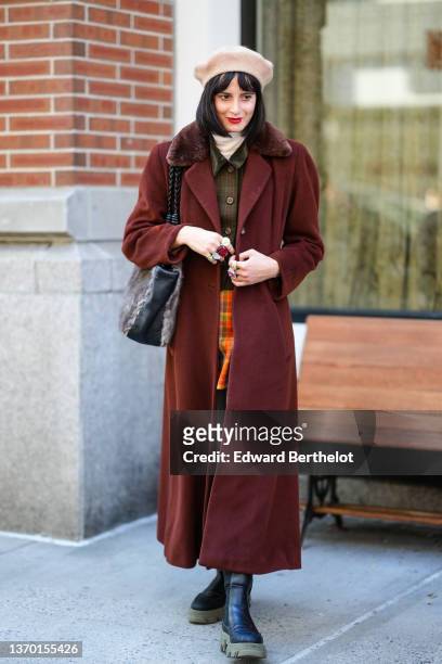 Guest wears a beige felt / wool beret, a white ribbed wool turtleneck pullover, a dark green and brown checkered print pattern jacket, a burgundy...