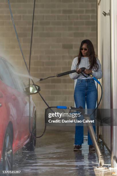 woman washes her car in a spray laundry garage - splash wasser stockfoto's en -beelden