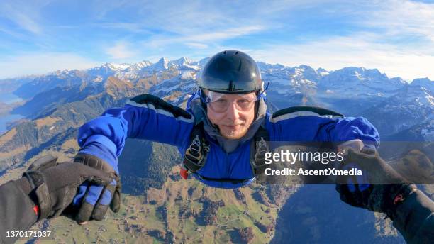 skydivers fall through clear skies, aerial flight - blue jumpsuit bildbanksfoton och bilder