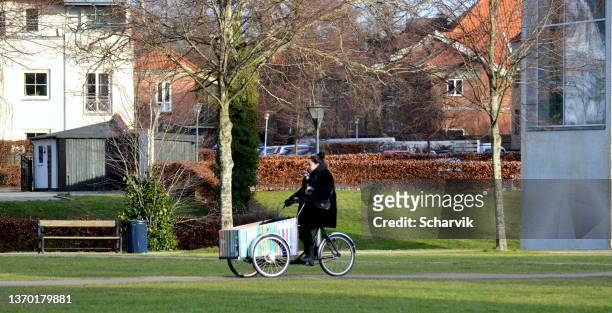 woman cycling in "ridebanen" a public park in hørsholm, denmark. - hørsholm stock pictures, royalty-free photos & images