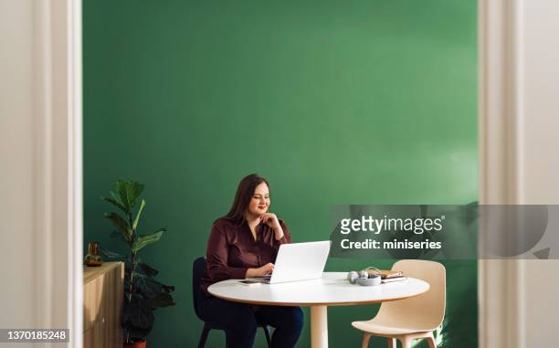 bela empresária plus size trabalhando em casa em seu laptop computador - mulher gorda - fotografias e filmes do acervo