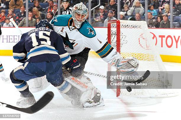 Thomas Greiss of the San Jose Sharks throws the puck away from Derek Dorsett of the Columbus Blue Jackets during the first period on January 14, 2012...